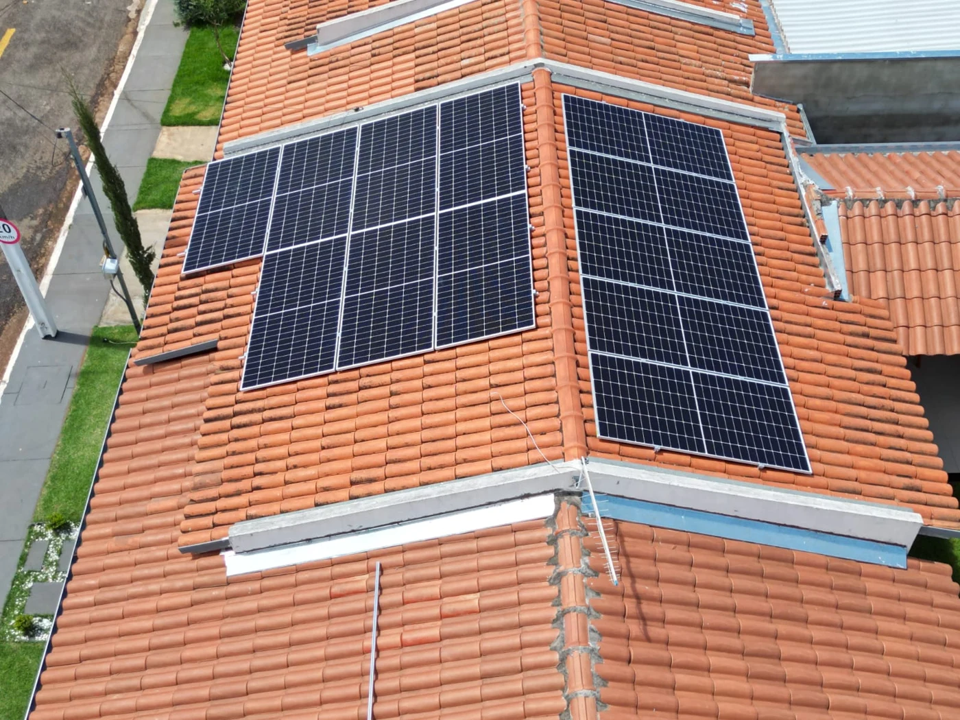 Vista aérea de módulos solares em duas águas de um telhado residencial